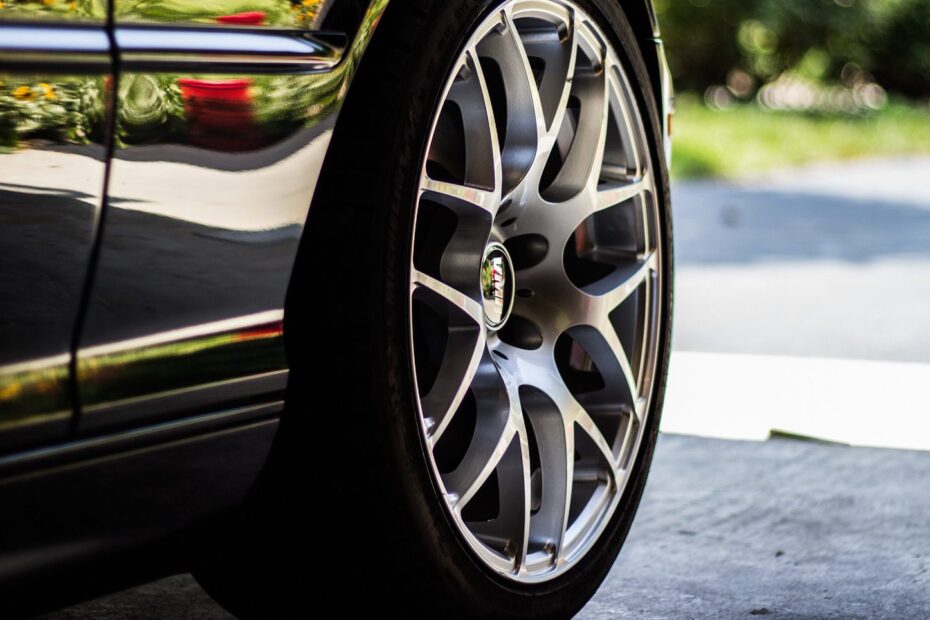 Close-up of a polished alloy wheel and tire on a clean black car.