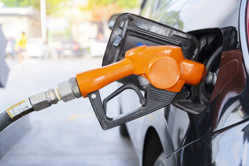 A fuel nozzle placed in the gas tank of a car.