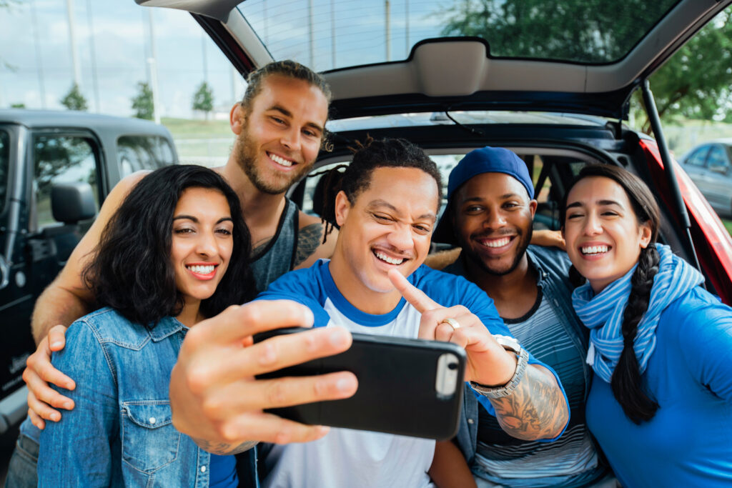 A group of friends taking a selfie at a tailgate event, enjoying the pre-game festivities with smiles and excitement.